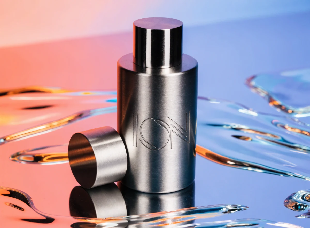 A playful commercial still life of a sleek metallic minimalist perfume bottle. Brushed steel or matte aluminum finish, c